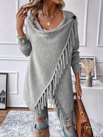 Woman wearing a gray fringe sweater in a room with decor elements.