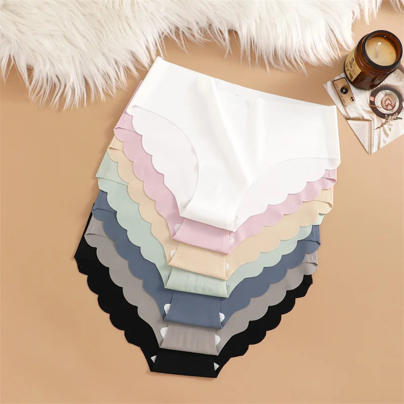 Stack of scalloped-edged fabric samples in various colors on a beige surface.