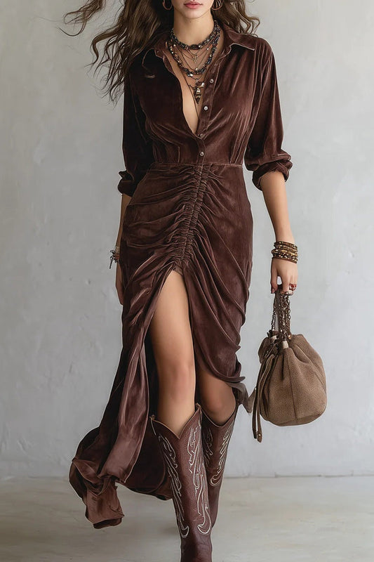 Woman wearing a brown velvet dress with a slit, paired with cowboy boots and holding a matching handbag.