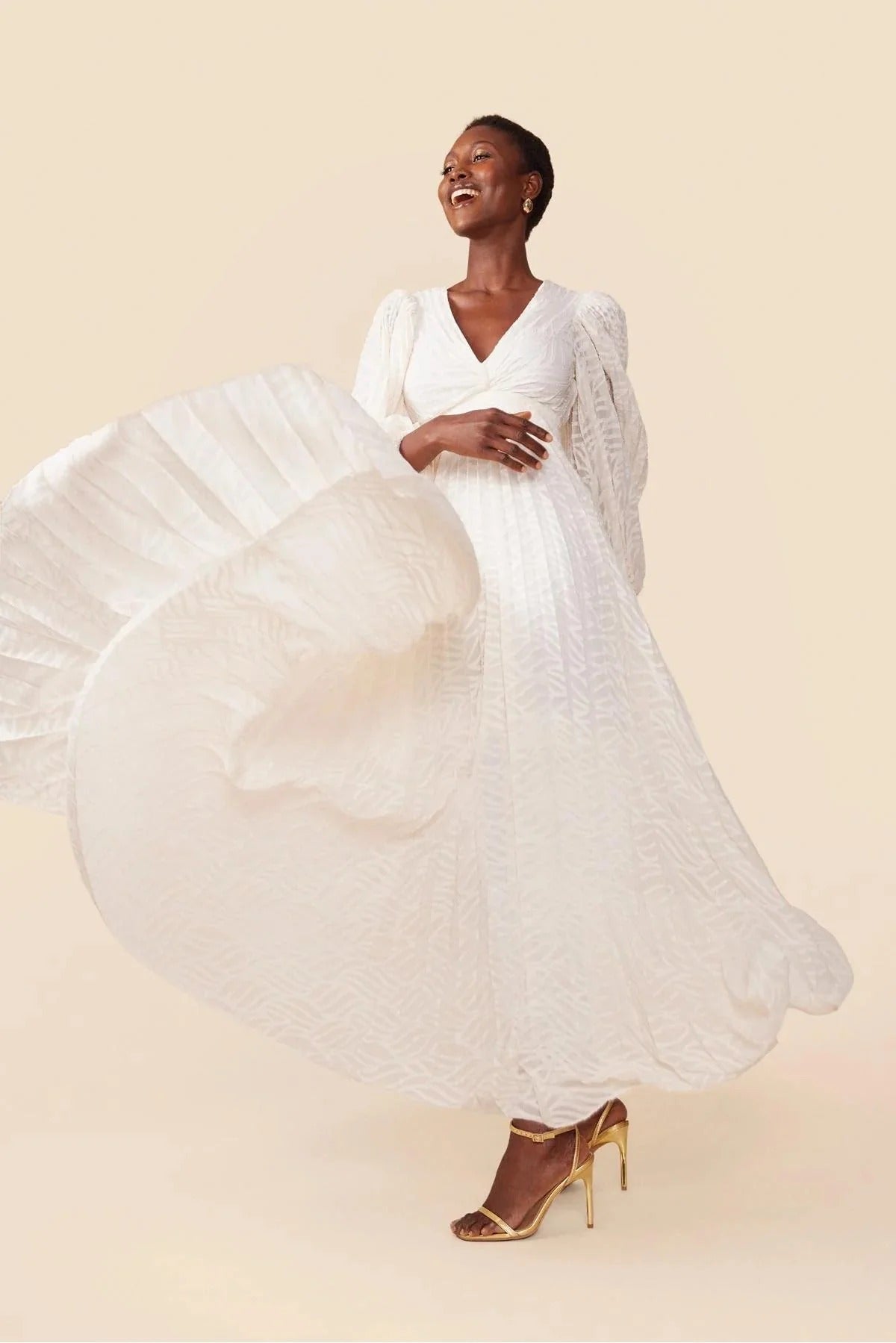 Woman in a flowing white dress on a beige background